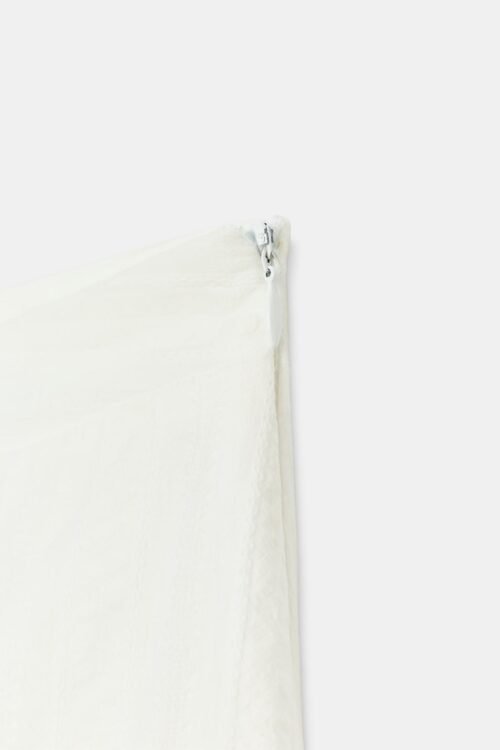 Jupe courte en coton bio blanc avec fermeture éclair visible sur le côté, détail produit