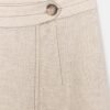 Jupe lin naturelle midi écru détail taille boutonnée en lin visible sur fond clair, couture verticale raffinée