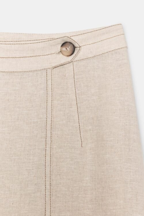 Jupe lin naturelle midi écru détail taille boutonnée en lin visible sur fond clair, couture verticale raffinée