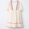 Robe lin écru fille avec galons festonnés bleu, orange et marron, manches courtes et jupe froncée