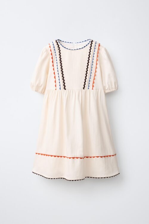 Robe lin écru fille avec galons festonnés bleu, orange et marron, manches courtes et jupe froncée