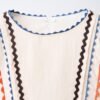 Robe fille en lin écru col rond avec galons ondulés bleu, marron et orange, détail devant
