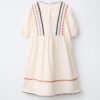 Robe fille en lin écru dos avec galons ondulés bleu, orange et noir, manches courtes bouffantes