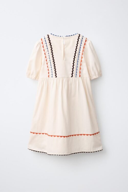 Robe fille en lin écru dos avec galons ondulés bleu, orange et noir, manches courtes bouffantes