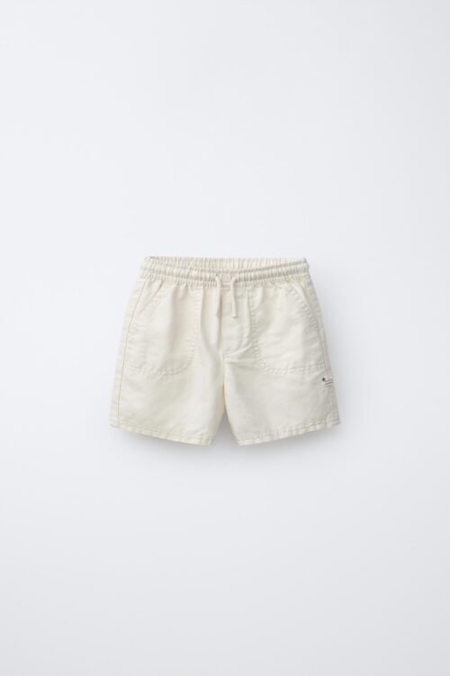 Short fille en coton bio blanc pur avec taille élastique et poches avant, produit durable pour enfant