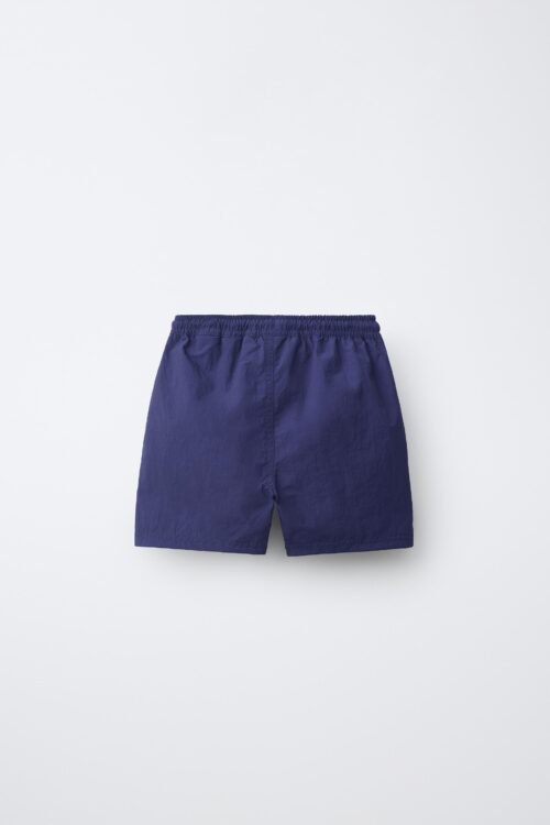 Short garçon en coton bio bleu uni, taille enfant, ceinture élastiquée visible, produit écologique
