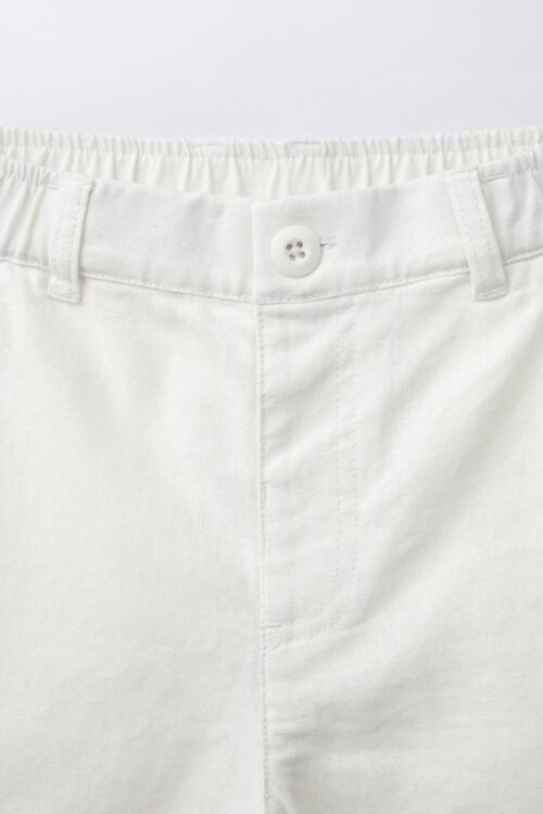 Short fille en lin naturel clair avec bouton sur ceinture élastiquée, détail produit visible
