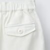Short fille en lin naturel clair avec poche à rabat et bouton, taille enfant, détail ceinture élastique