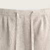 Short en lin naturel écru avec cordon ajustable à taille élastiquée, texture visible et plis devant